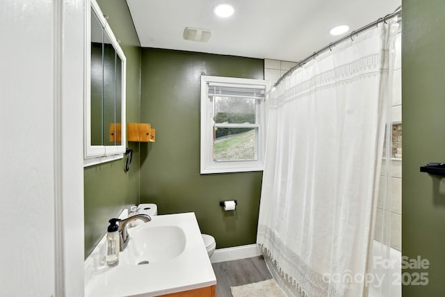 bathroom featuring baseboards, a shower with shower curtain, toilet, wood finished floors, and vanity