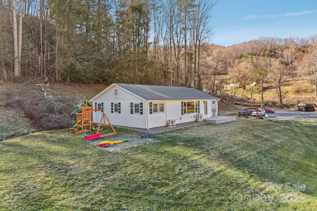 rear view of house featuring a yard and a playground