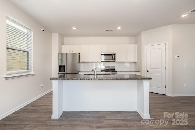 kitchen with white cabinetry, sink, appliances with stainless steel finishes, and dark stone counters