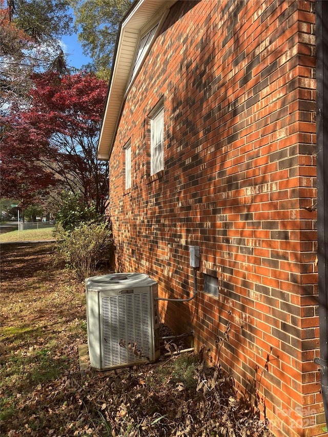 view of home's exterior with central air condition unit and brick siding