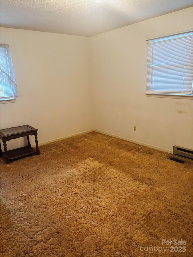 carpeted spare room featuring baseboards