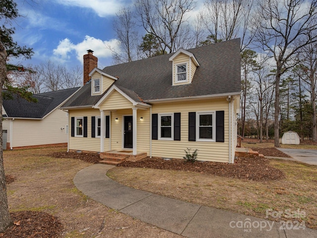 cape cod-style house featuring a shed