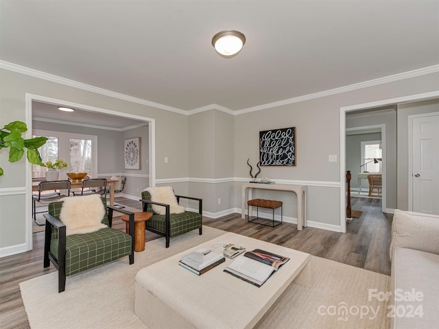 living room featuring wood-type flooring and crown molding