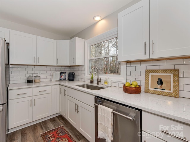 kitchen with white cabinetry, sink, stainless steel appliances, dark hardwood / wood-style floors, and backsplash