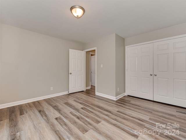 unfurnished bedroom featuring light hardwood / wood-style floors and a closet