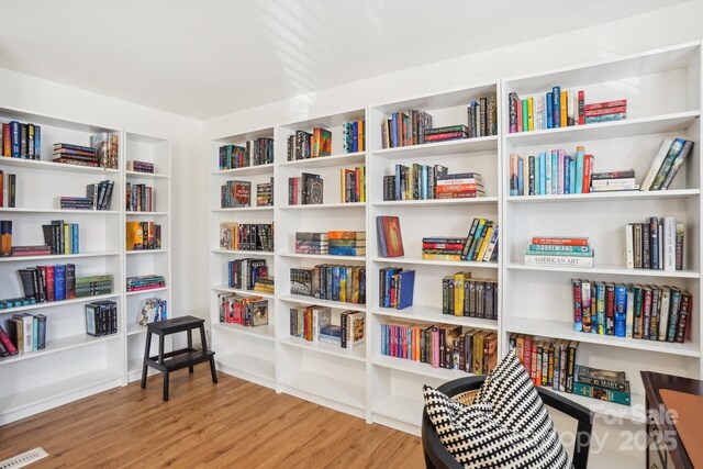 5300 Fair Wind Ln, Charlotte, NC 28212 - sitting room featuring visible vents, wood finished floors, and wall of books