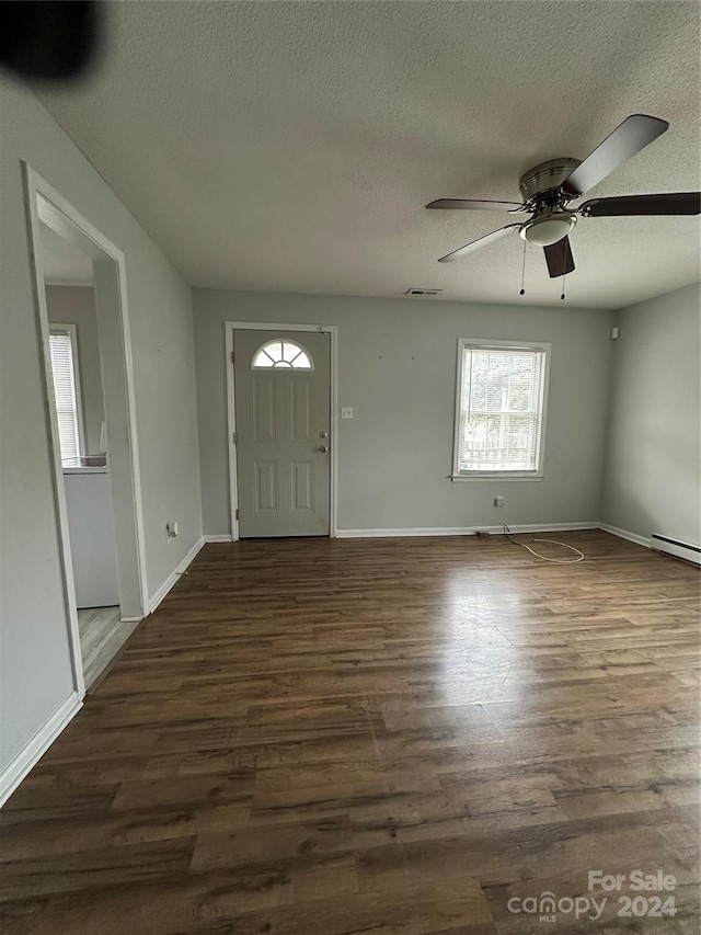 entrance foyer featuring a textured ceiling, ceiling fan, and dark wood-type flooring