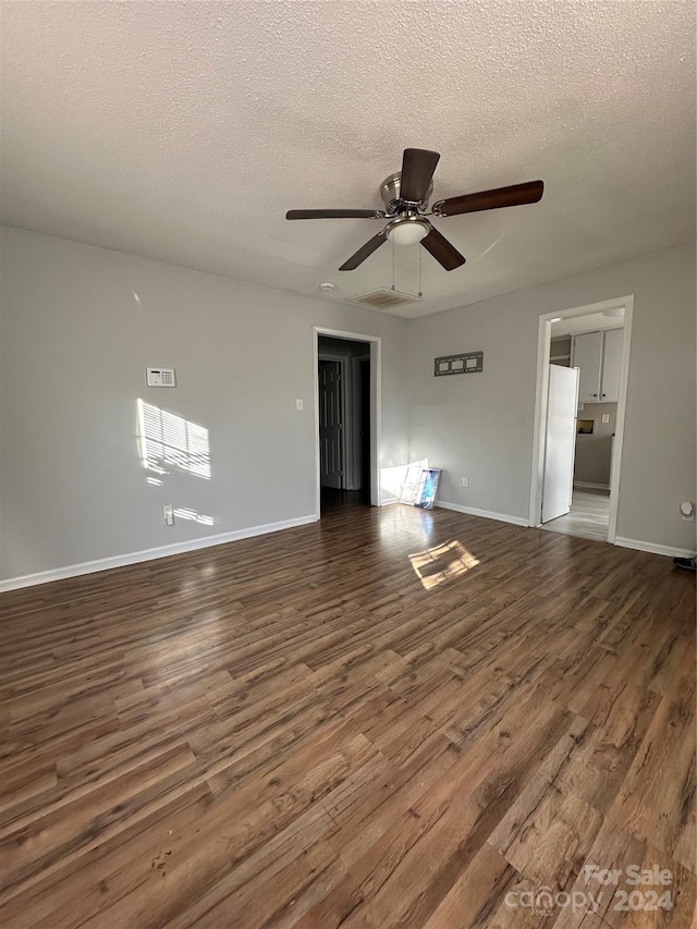 interior space with ceiling fan, dark wood-type flooring, and a textured ceiling