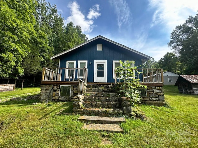 back of house featuring a yard and a deck