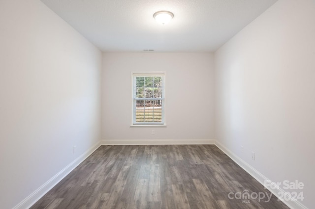 empty room with dark wood-type flooring