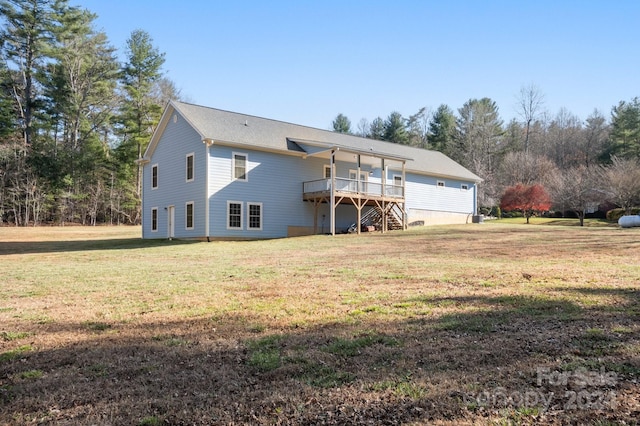 rear view of property with a lawn and a wooden deck