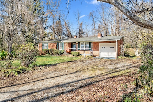 ranch-style home with covered porch, a garage, and a front lawn