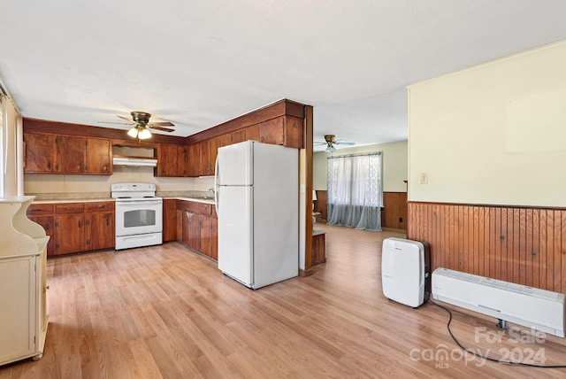 kitchen featuring white appliances, ceiling fan, sink, light hardwood / wood-style flooring, and wood walls