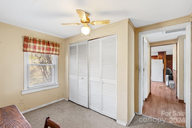 bedroom featuring a closet, white fridge, ceiling fan, and carpet floors