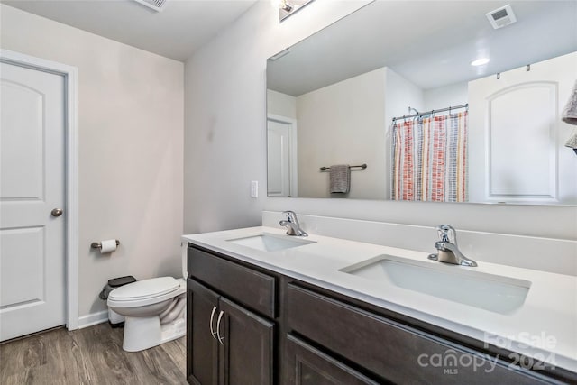 bathroom featuring vanity, hardwood / wood-style flooring, and toilet