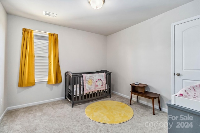 carpeted bedroom with a nursery area