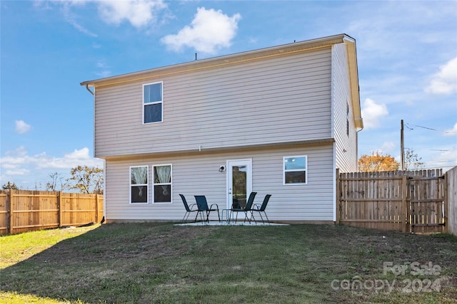 rear view of house with a lawn and a patio