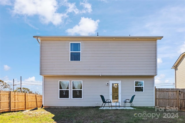 back of house featuring a patio area and a yard