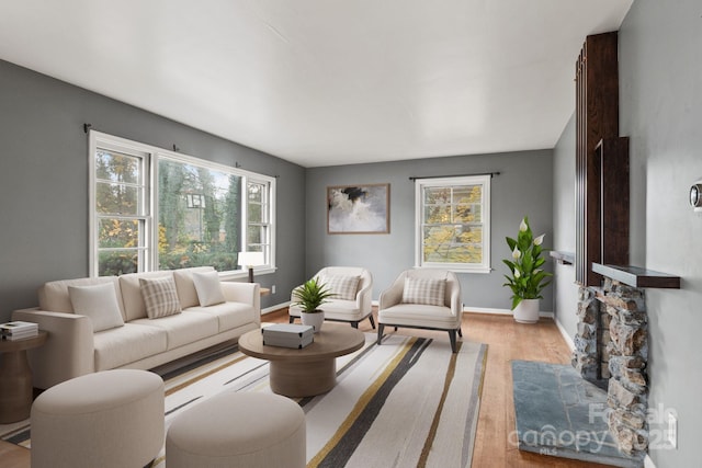 living room featuring light wood finished floors, baseboards, and a wealth of natural light