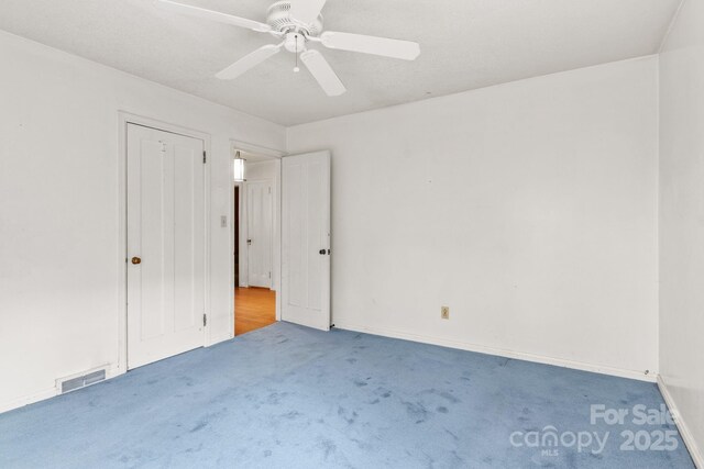 unfurnished bedroom with visible vents, carpet flooring, baseboards, and ceiling fan