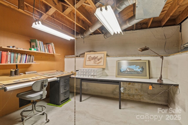 office area with a workshop area and unfinished concrete flooring