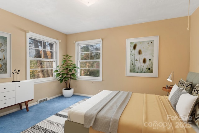 carpeted bedroom featuring visible vents and baseboards