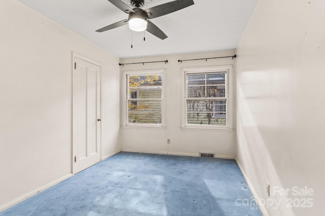 carpeted spare room with a ceiling fan, baseboards, and visible vents