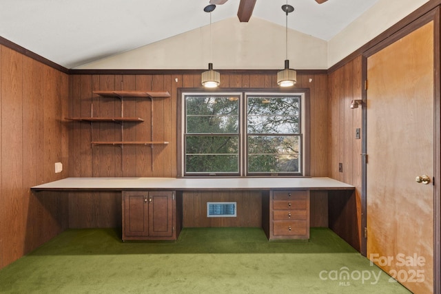 unfurnished office featuring built in desk, carpet, and lofted ceiling