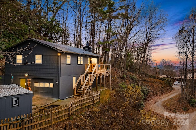 back house at dusk featuring a garage