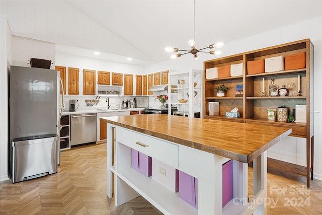 kitchen with hanging light fixtures, stainless steel appliances, wood counters, a chandelier, and light parquet flooring