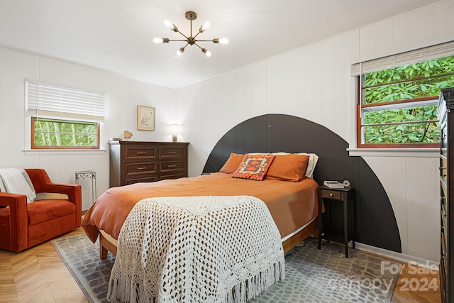 bedroom featuring parquet flooring and an inviting chandelier