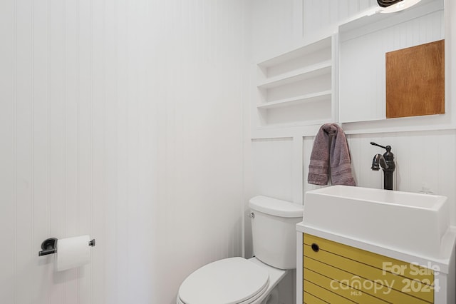 bathroom featuring vanity, toilet, and wooden walls