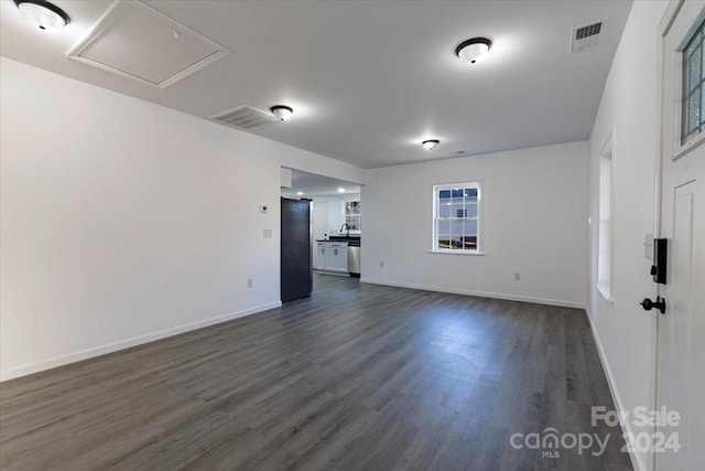 unfurnished living room with dark hardwood / wood-style floors and sink