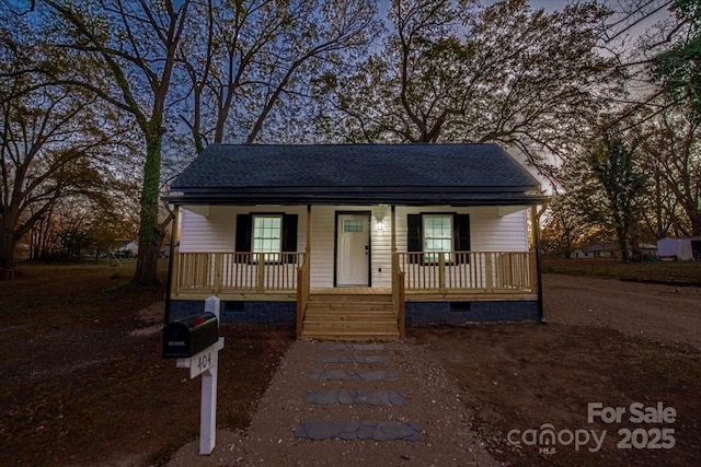 bungalow with a porch, crawl space, and roof with shingles