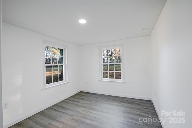 empty room with recessed lighting, baseboards, and wood finished floors