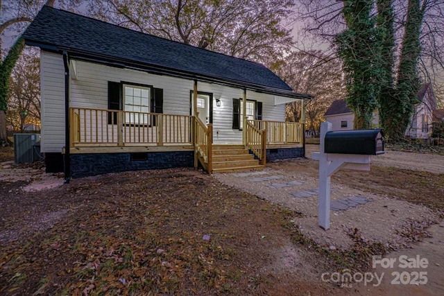 view of front of home with roof with shingles and covered porch