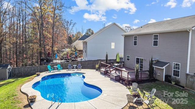 view of pool featuring a deck, a grill, and a lawn