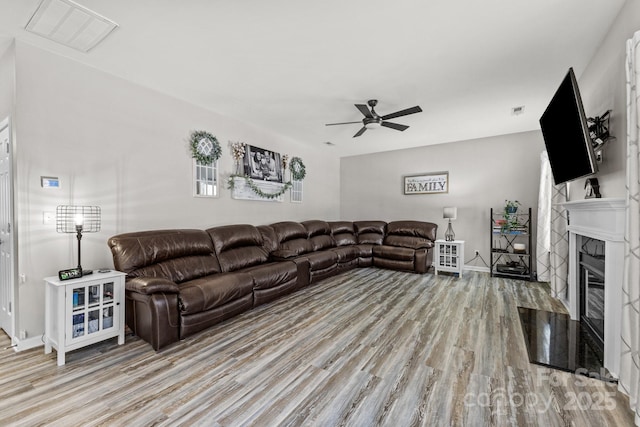 living room featuring ceiling fan and light hardwood / wood-style flooring