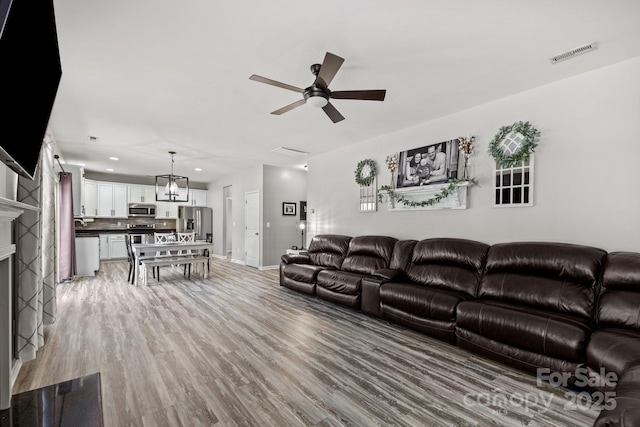 living room with light wood-type flooring and ceiling fan