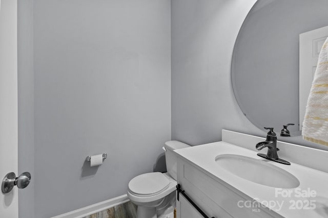 bathroom featuring toilet, hardwood / wood-style flooring, and vanity