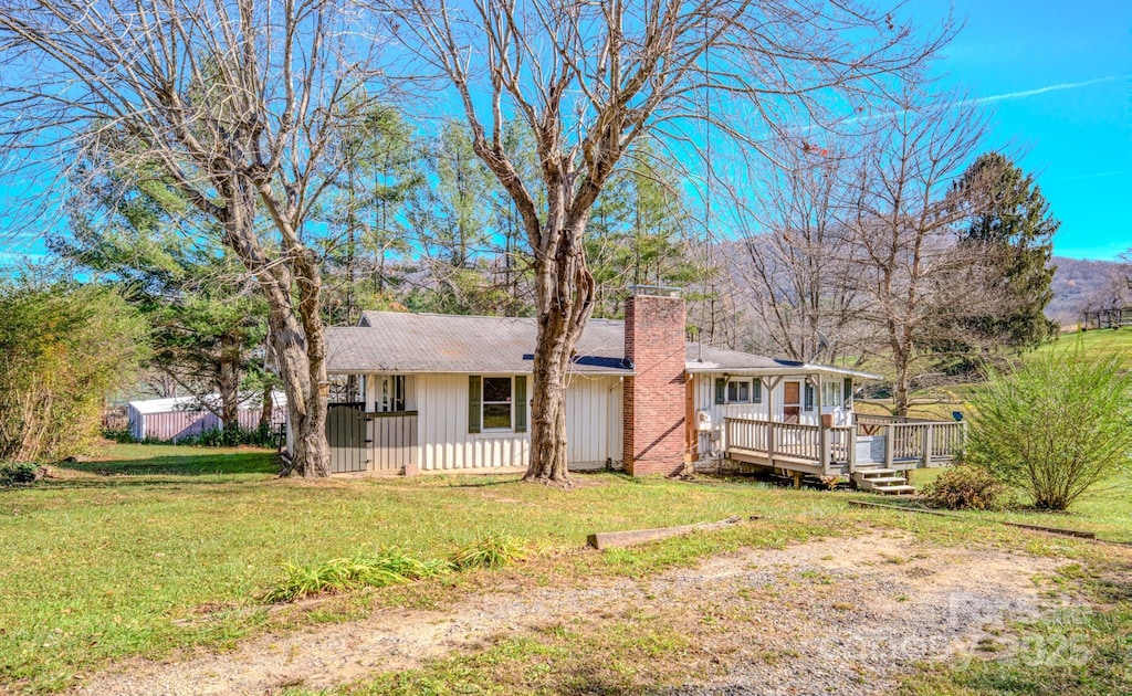 single story home with a front lawn and a wooden deck