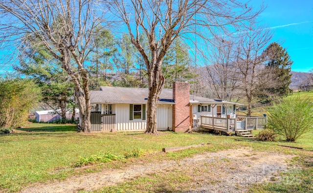 single story home with a front lawn and a wooden deck