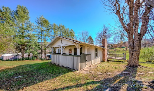 view of side of home with a wooden deck and a lawn