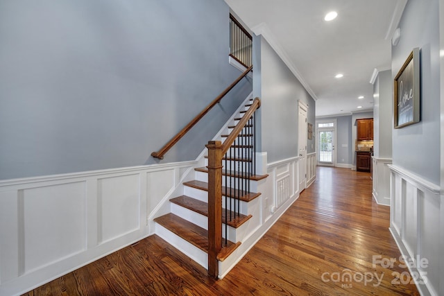 stairs with hardwood / wood-style flooring and ornamental molding