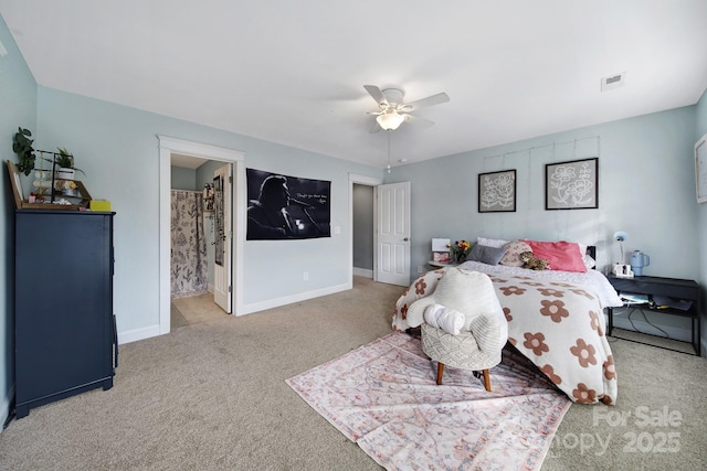 bedroom featuring light colored carpet, ceiling fan, and ensuite bathroom