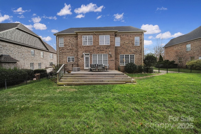 back of property featuring a wooden deck and a yard