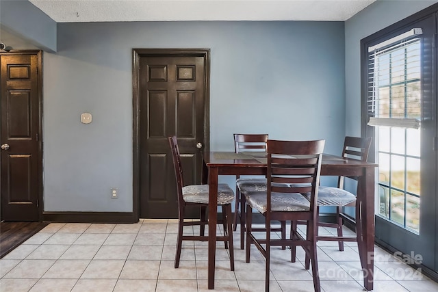 tiled dining area with a textured ceiling