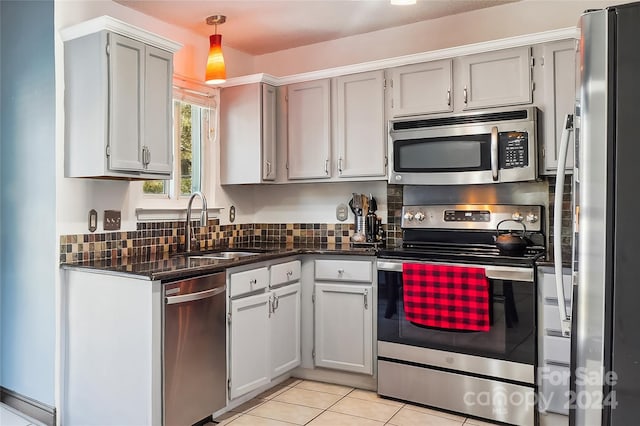 kitchen with appliances with stainless steel finishes, sink, light tile patterned floors, pendant lighting, and gray cabinets