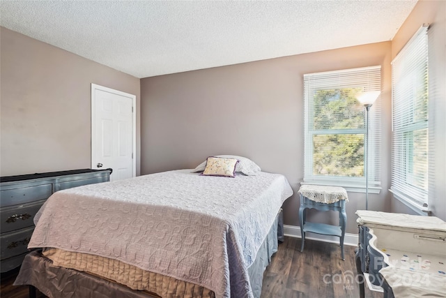 bedroom with a textured ceiling and dark wood-type flooring