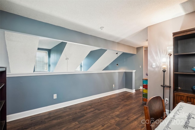 home office featuring a textured ceiling, dark hardwood / wood-style flooring, and vaulted ceiling